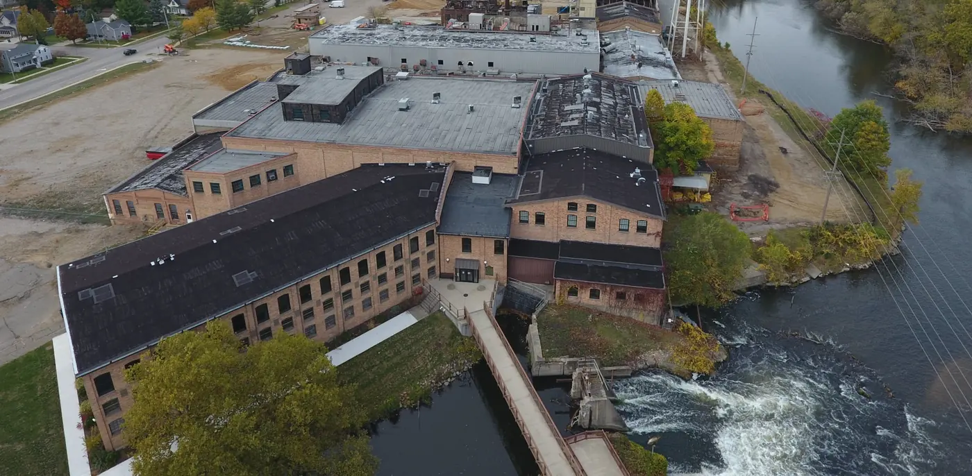 Aerial view of City Hall in the former paper mill, the footbridge and the dam on the Kalamazoo River in fall