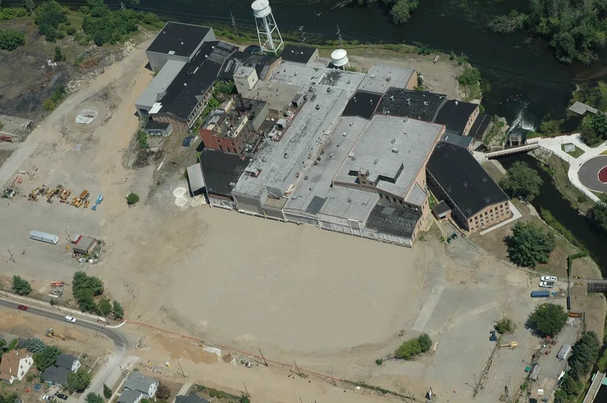 Aerial view of the paper mill buildings and cleared land during demolition