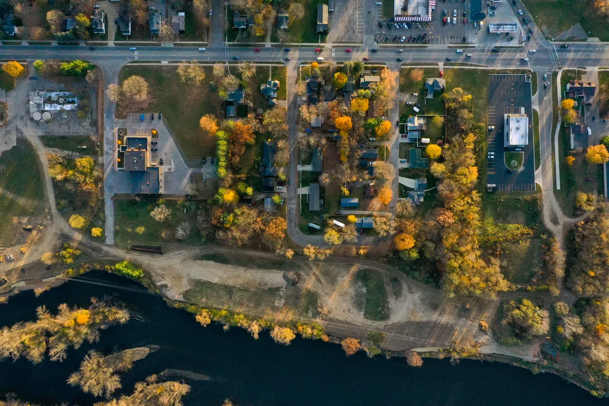 Overhead drone view of the Kalamazoo River and the neighborhood beside the mill site in fall