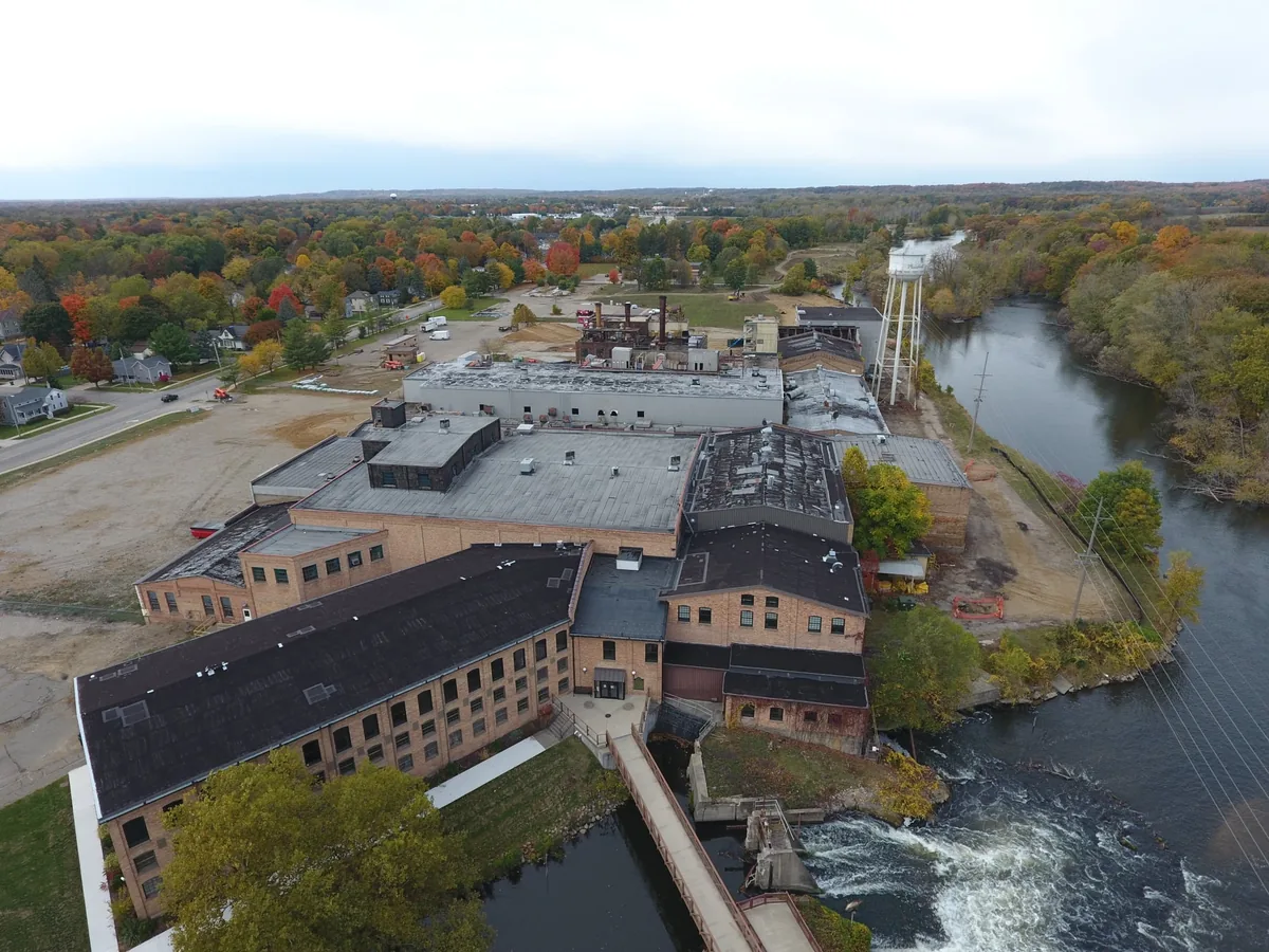 Drone view of the historic brick mill buildings along the Kalamazoo River in fall